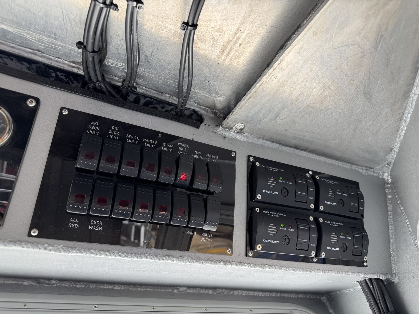 Finished helm switch panel with labelled rocker switches and bilge pump alarms